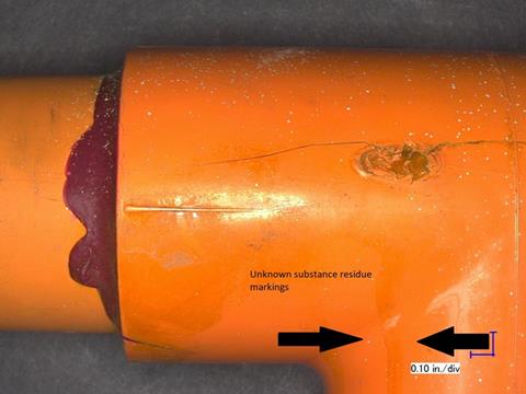 Laboratory image documenting residue markings on the exterior of the failed CPVC tee
