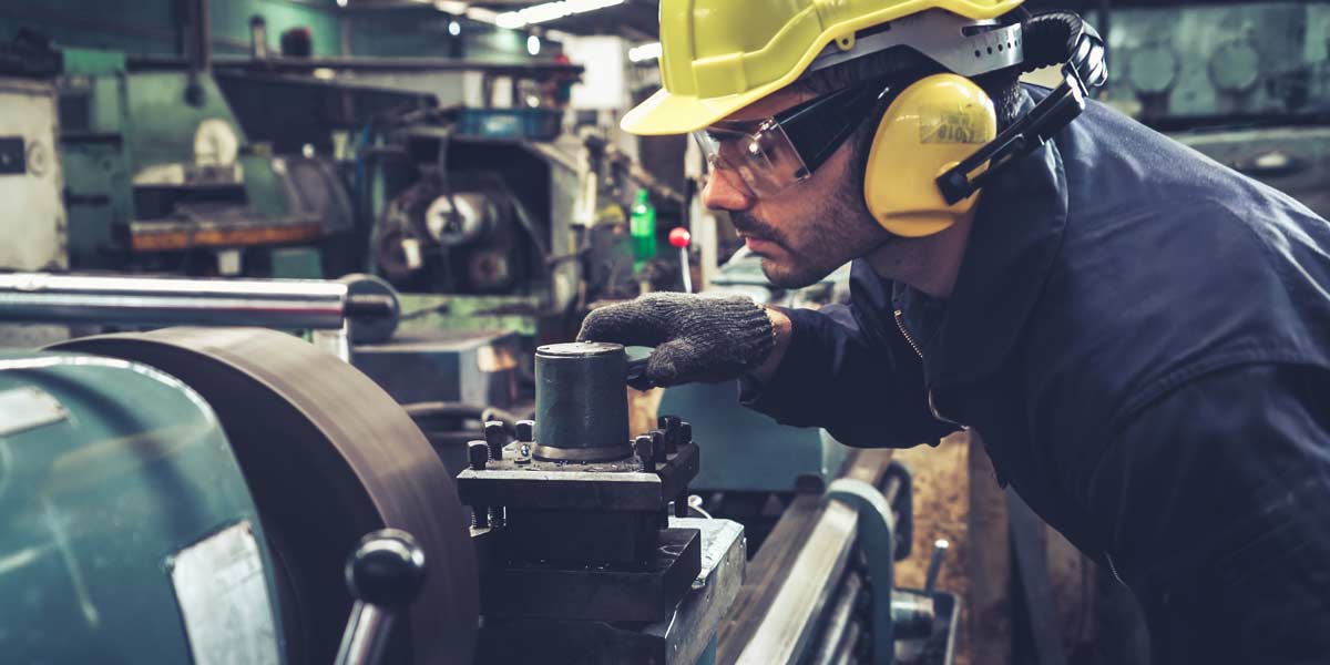 Smart factory worker using machine in factory workshop