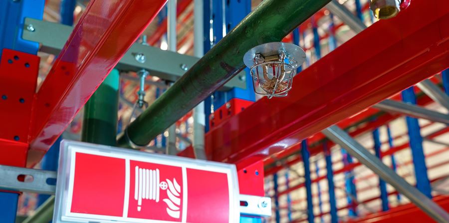fire sprinkler in a large warehouse with metal shelving