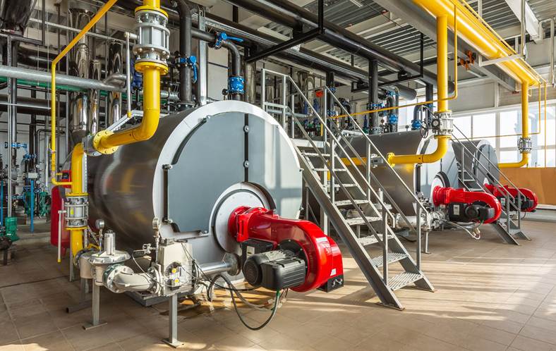 the interior of an industrial boiler room with three large boilers many pipes valves and sensors