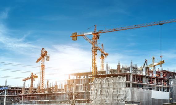 panorama view at workers are working on large construction sites and many cranes are working in the industry new building business 1