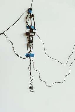 Improperly managed extension cords taped to a wall, illustrating potential safety hazards and the importance of safe usage practices.