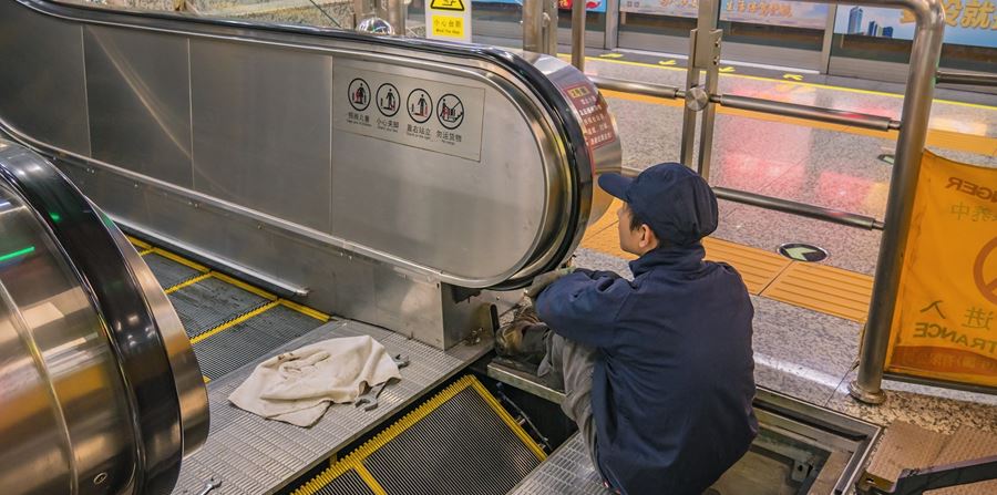 worker examining broken escaltor